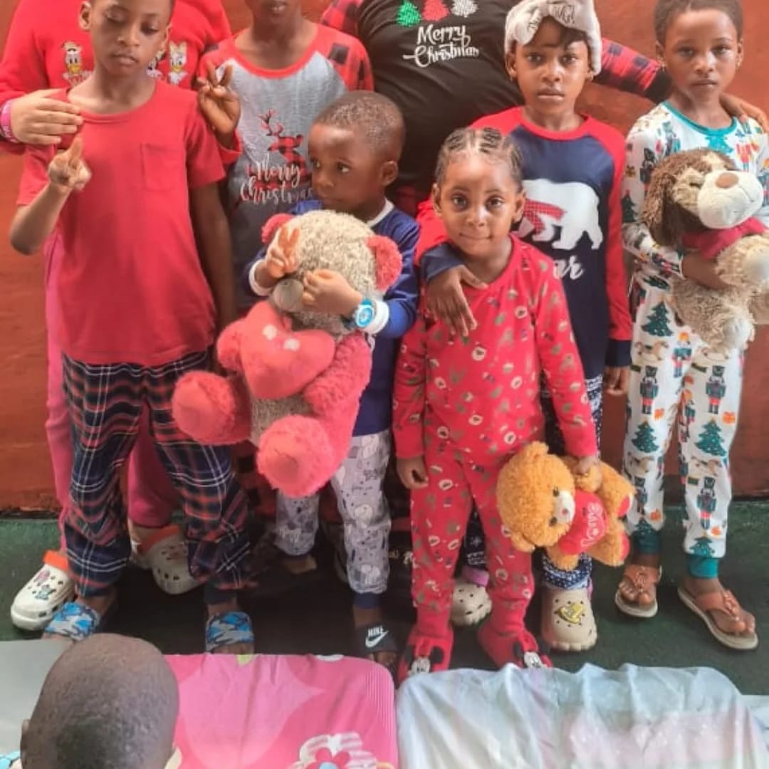 Pupils in Christmas pajamas holding teddy bears