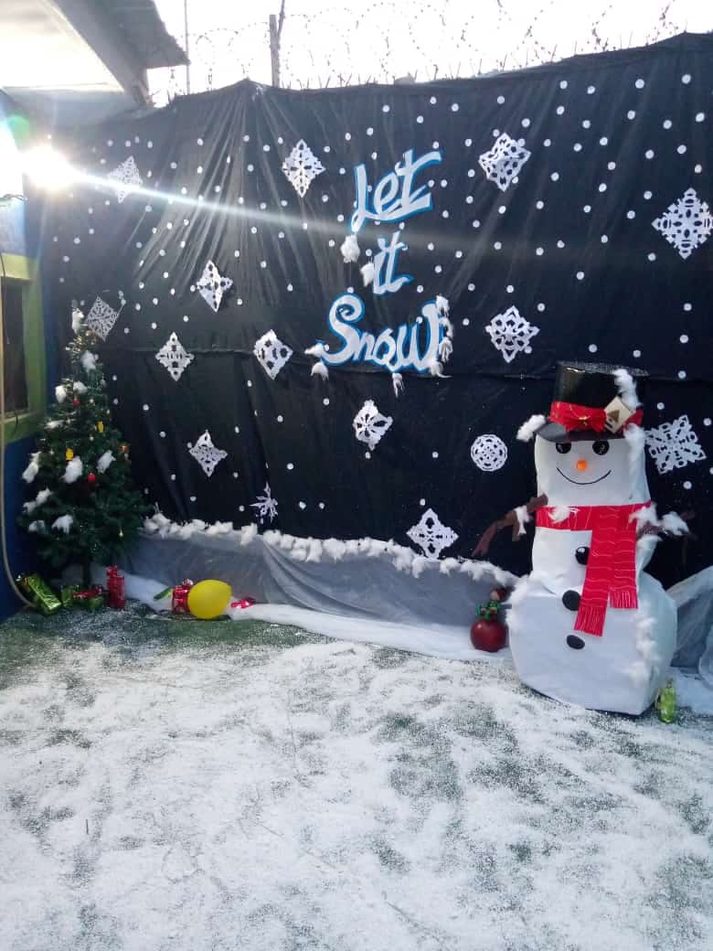 A Let It Snow themed Christmas display with a snowman and decorated tree