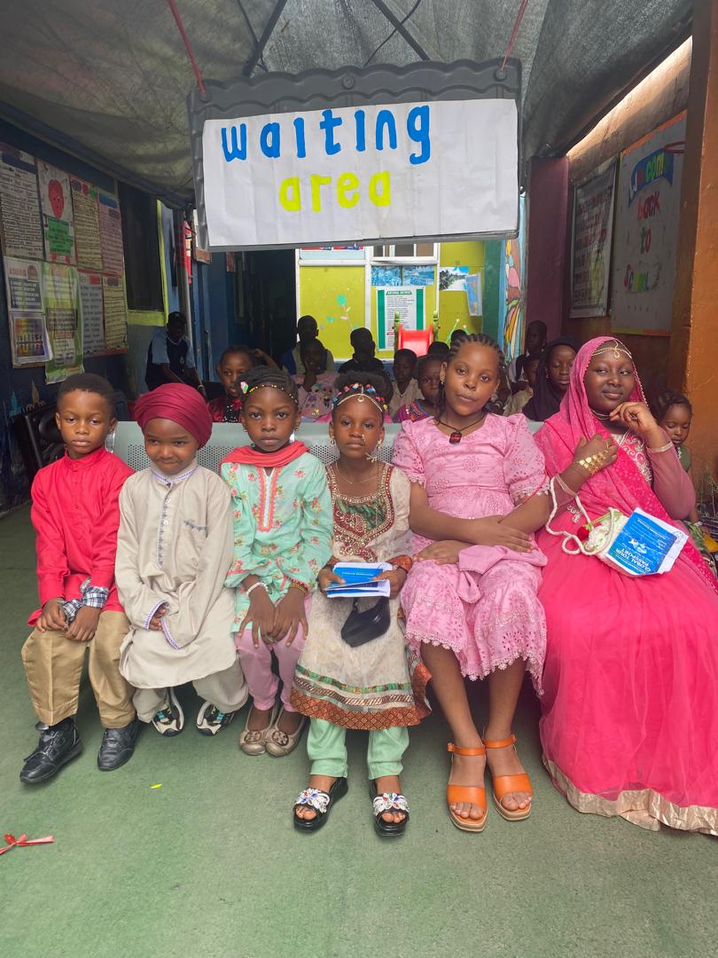 Pupils in traditional attire waiting their turn for Global Tour Passport Day
