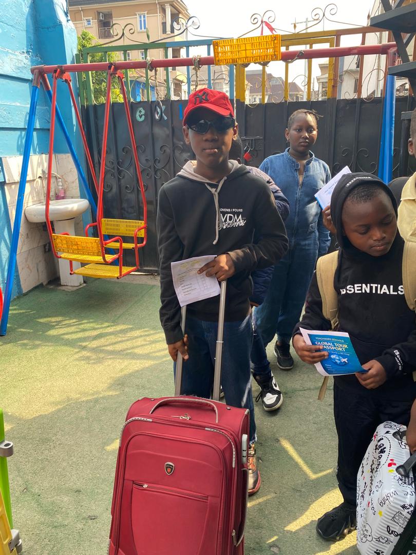A pupil with travel luggage during Global Tour Passport Day