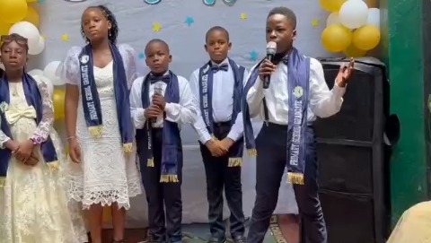 Pupils in sashes giving a speech on stage at the Peachmark Prize-Giving Day